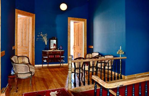 a room with blue walls and a table and chairs at VASILIKON Hotel 1888 the past is present in Kalamata