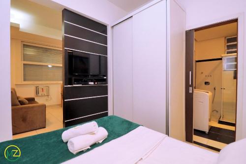 1 dormitorio con 1 cama con 2 toallas en Silencioso e aconchegante studio em Copacabana, en Río de Janeiro