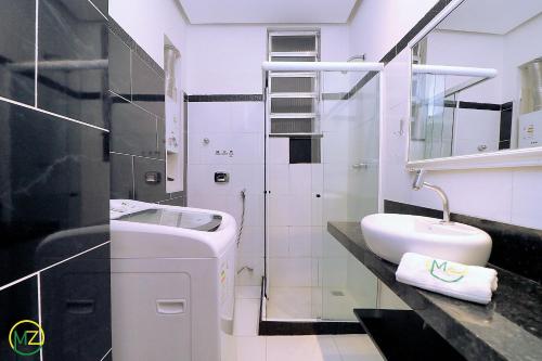 Baño blanco con lavabo y aseo en Silencioso e aconchegante studio em Copacabana, en Río de Janeiro