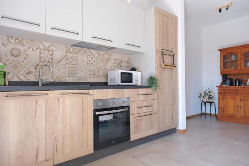 a kitchen with wooden cabinets and a microwave at Ca' Sunin Bellagio - mountains view apartment in Bellagio