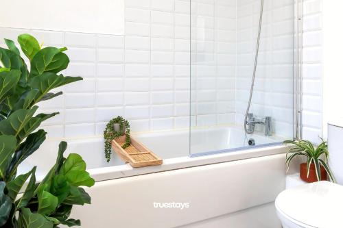 uma casa de banho com uma banheira com plantas em NEW Balfour House by Truestays - 5 Bedroom House in Stoke-on-Trent em Etruria