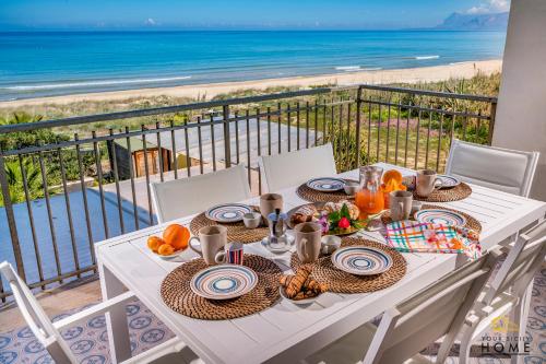 een tafel met eten en uitzicht op de oceaan bij Casa Vacanze Mare Dorato in Alcamo Marina