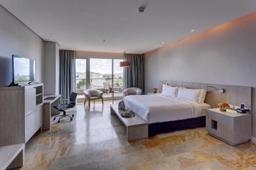 a hotel room with a bed and a television at GHL Hotel Monteria in Montería