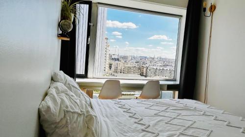 ein Schlafzimmer mit einem Bett und einem großen Fenster in der Unterkunft Montparnasse, 2 cozy private rooms in shared apartment in Paris
