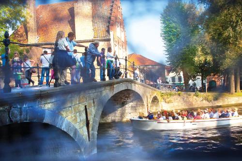 a group of people on a boat on a bridge at Grand Hotel Casselbergh in Bruges