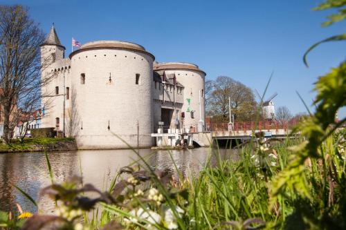 a castle with a bridge over a body of water at Grand Hotel Casselbergh in Bruges