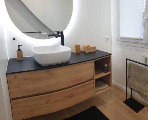 une salle de bain avec un lavabo et un miroir sur un comptoir dans l'établissement Maison familiale proche plages, centre-ville, à Concarneau