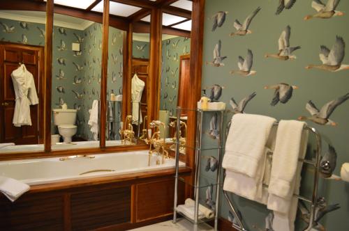 a bathroom with a tub and a bird wallpaper at Kinloch House Hotel in Blairgowrie