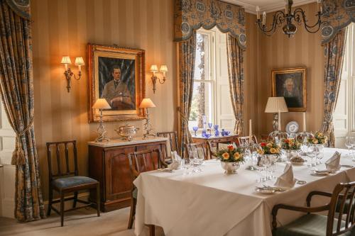 a dining room with a long table with flowers on it at Kinloch House Hotel in Blairgowrie
