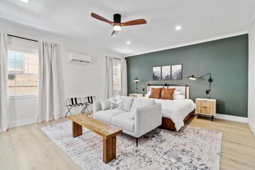 a bedroom with a bed and a couch and a ceiling fan at 27 on Park Boutique Hotel & Venue in Dahlonega