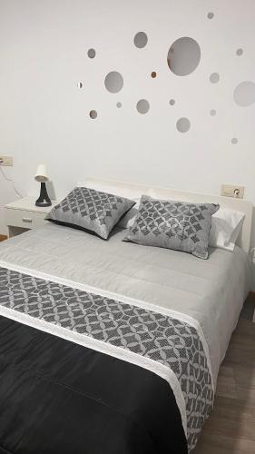 a bedroom with a large bed with gray pillows at La de Fredyy - Tres Marias Apartments in Redondela