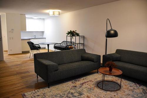 Sala de estar con 2 sofás y mesa en Ferienwohnung Bodenseeblick Nr 9 en Scheidegg