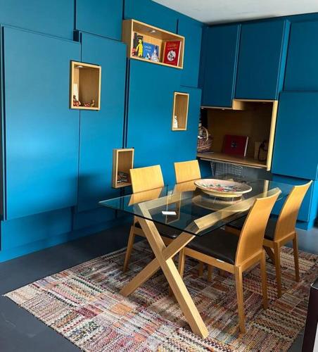 une salle à manger avec des murs bleus et une table et des chaises dans l'établissement Le PARADIS Joli cocon bien agencé avec terrasse traversante, à Boulogne-Billancourt