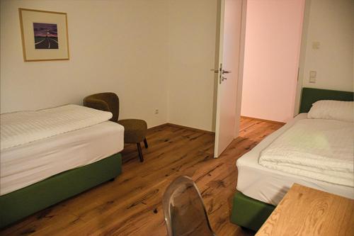 Habitación con 2 camas, mesa y sillas en Ferienwohnung Bodenseeblick Nr 10, en Scheidegg