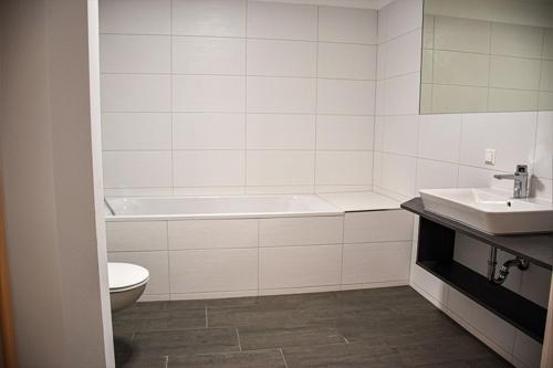 uma casa de banho com uma banheira, um WC e um lavatório. em Ferienwohnung Bodenseeblick Nr 10 em Scheidegg