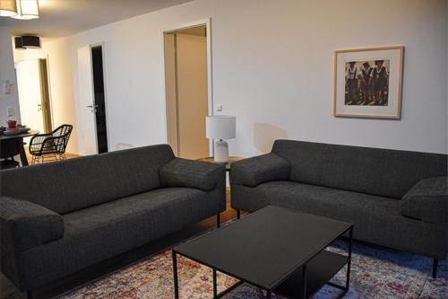 a living room with two couches and a table at Ferienwohnung Bodenseeblick Nr 8 in Scheidegg