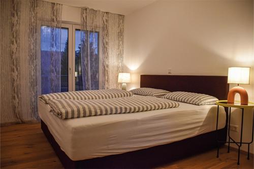 a bedroom with a large bed and a large window at Ferienwohnung Bodenseeblick Nr 8 in Scheidegg