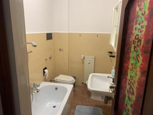 La salle de bains est pourvue d'une baignoire, de toilettes et d'un lavabo. dans l'établissement Appartamento nel cuore della Valsassina, à Moggio