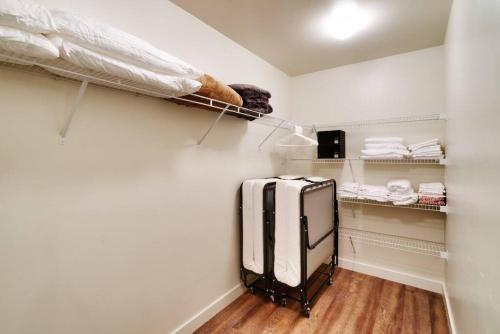 vestidor con cama y maleta en 2K Top Floor Moab RedCliff Condo, POOL & HOT TUB, en Moab