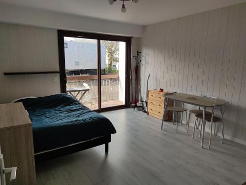 een slaapkamer met een bed, een bureau en een tafel bij Studio proche centre-ville et gare in Dax