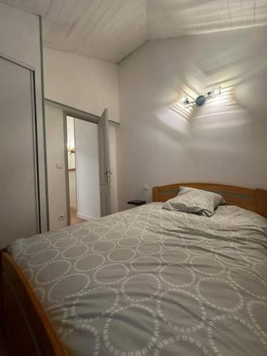a bedroom with a bed with a white comforter at Appartement F2 cosy en duplex Hyper Centre Bourgogne in Orléans