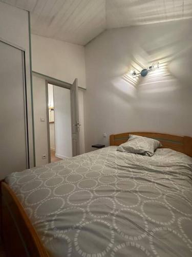 une chambre avec un lit avec une couette blanche dans l'établissement Le Cosy - Duplex Hyper Centre Bourgogne - Netflix, à Orléans