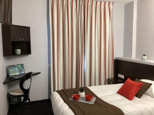 a hotel room with a bed with a tray of food on it at Hôtel Alliance in Lourdes