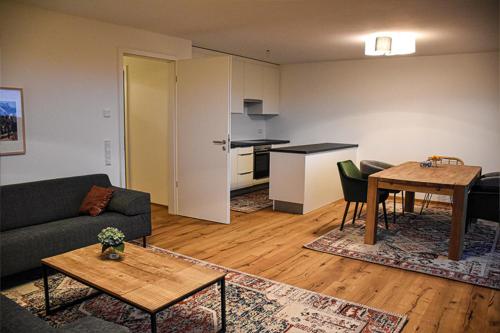 uma sala de estar com um sofá e uma mesa em Ferienwohnung Bodenseeblick Nr 6 em Scheidegg
