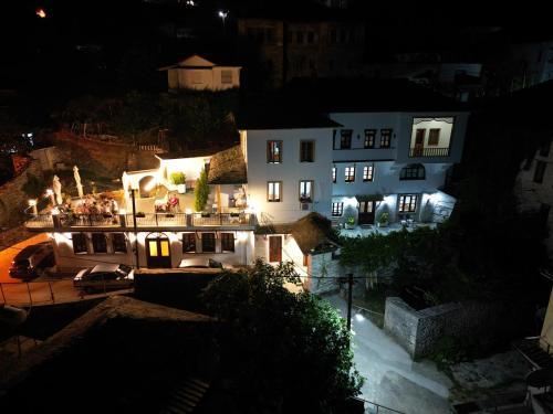 a large white house at night with lights at Castle Hotel in Gjirokastër