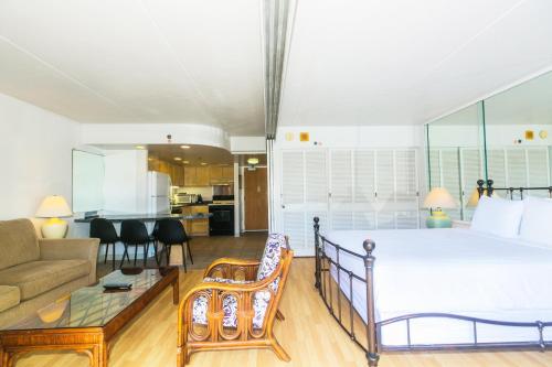 een slaapkamer met een groot bed en een woonkamer bij Ilikai Tower 1936 Lagoon View 1BR in Honolulu