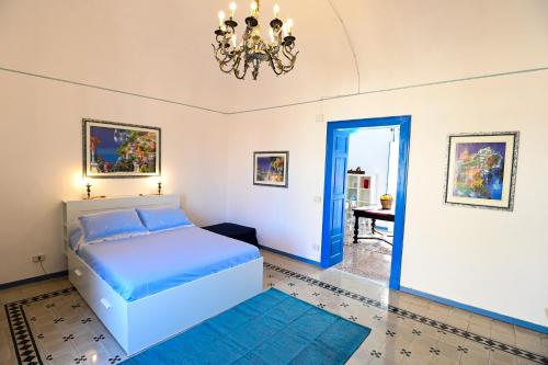 um quarto com uma cama azul e um lustre em La Ciriciccia em Acireale
