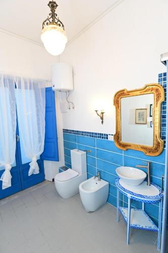 uma casa de banho com um WC, um lavatório e um espelho. em La Ciriciccia em Acireale