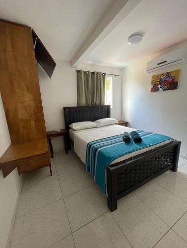 a bedroom with a bed with two black shoes on it at Residencial Fran Chiattone in Natal