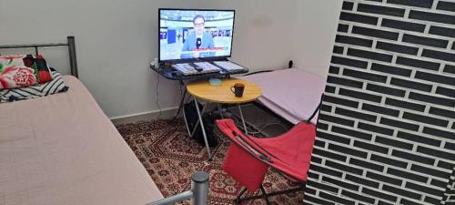 Habitación pequeña con mesa y ordenador portátil. en MOHAMMAD HOSTEL en Mascate