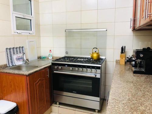 y cocina con fogones y hervidor de agua. en MOHAMMAD HOSTEL en Mascate