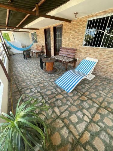 a patio with a hammock and chairs and a table at Residencial Fran Chiattone in Natal