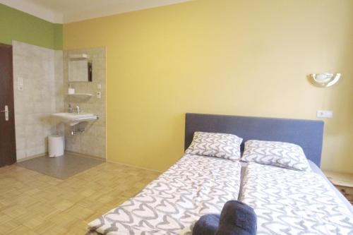 ein Schlafzimmer mit einem Bett und ein Badezimmer mit einem Waschbecken in der Unterkunft Double Room in Hütteldorfer Straße Area in Wien