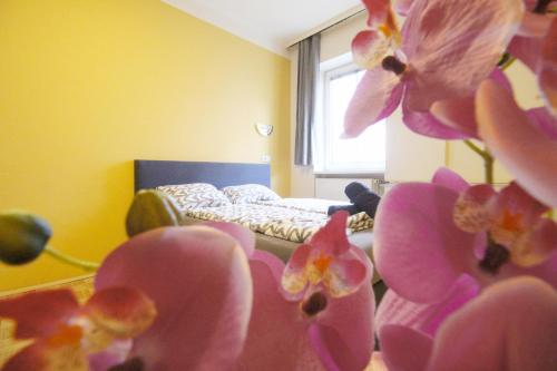 a bedroom with a bed with pink flowers in the foreground at Double Room in Hütteldorfer Straße Area in Vienna
