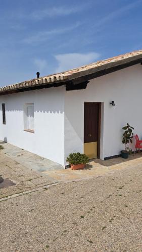 un edificio blanco con puerta y ventana en Estudio 1 Hacienda Torrepalma, en Torrepalma