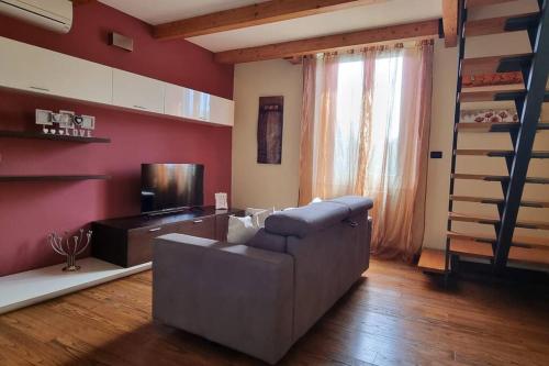 ein Wohnzimmer mit einem Sofa und einem TV in der Unterkunft Appartamento La casina di Chiara in Livorno