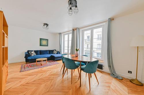 a living room with a table and a blue couch at PANTHEON in Paris