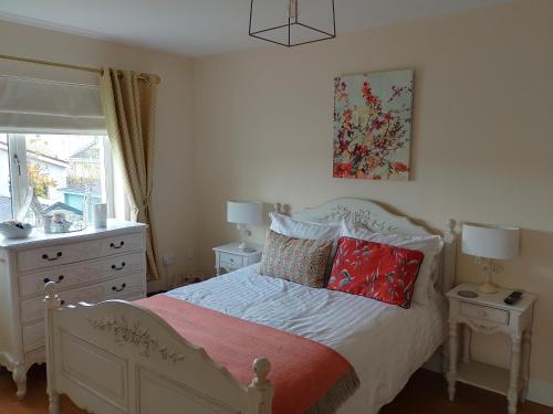 Un dormitorio con una cama con almohadas rojas y una ventana en El Roi Guesthouse, en Waterford