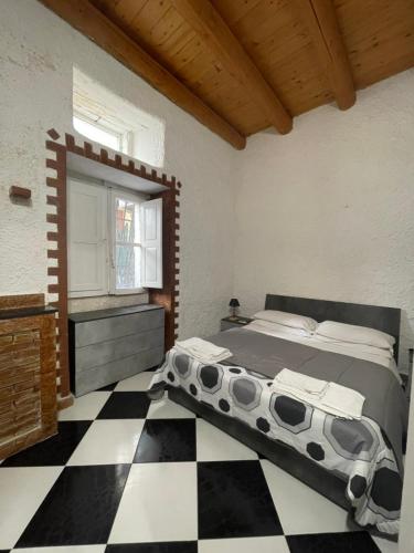 a bedroom with a bed and a checkered floor at Il Cortiletto di Ortigia in Syracuse