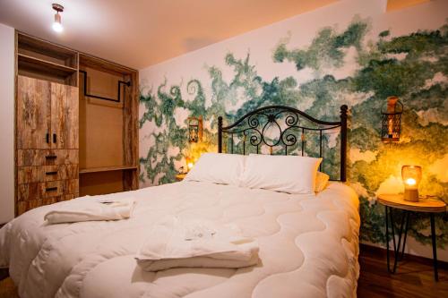 庫斯科的住宿－INYAWASI APARTMENT，卧室配有一张大床,墙上挂有绘画作品