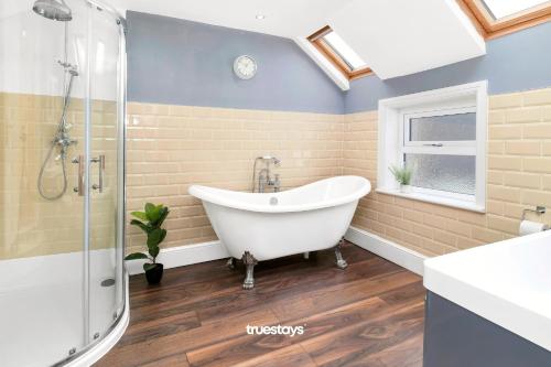 a bathroom with a white tub and a shower at NEW Lily House by Truestays - 3 Bedroom House in Stoke-on-Trent in Newcastle under Lyme