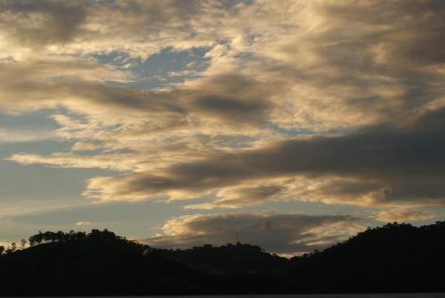 a cloudy sky with trees in the background at Hostal Casa Verde in Santa Ana