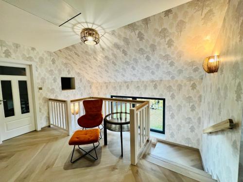 um quarto com uma escada e uma cadeira vermelha em Lilac House - holiday and relaxation house em Ohrobec