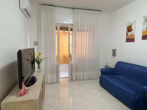 ein Wohnzimmer mit einem blauen Sofa und einem TV in der Unterkunft Casa Bettina in Piombino