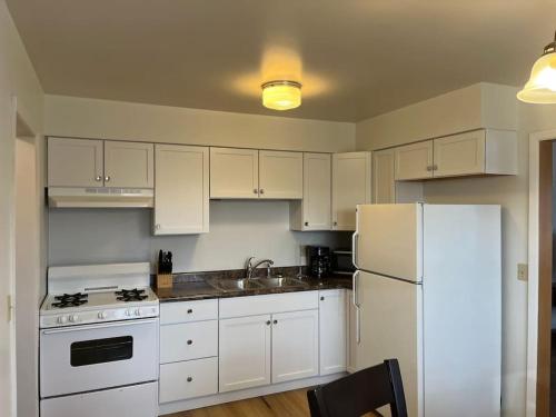 a kitchen with white cabinets and a white refrigerator at Entire apartment close to downtown - 2 queen beds in Springfield