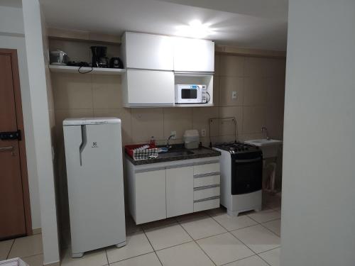 uma cozinha com um frigorífico branco e um micro-ondas em Apartamento mobiliado e confortável em candeias no Recife